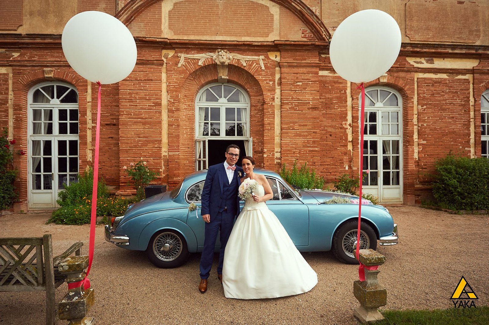 Couple de mariés avec voiture ancienne et ballons, photographié près de Toulouse